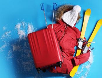 Suitcase with warm clothes and skis 