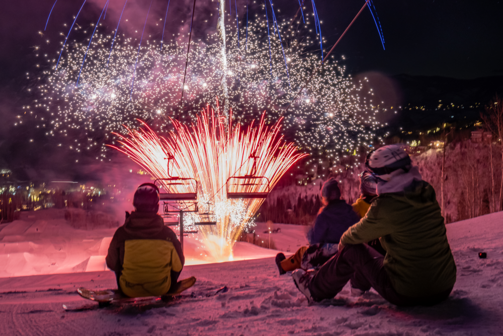 Skiers watching NYE fireworks on the mountain.