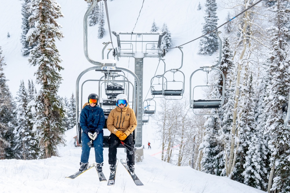 Two people riding a ski lift.
